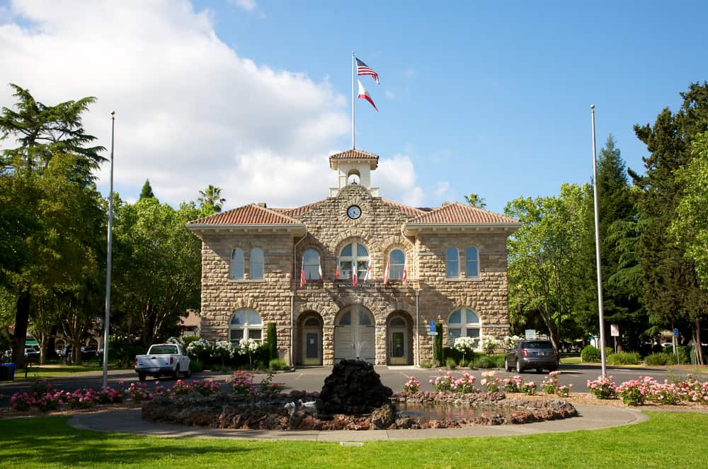 Symmetrical stone building with trees and plaza that is Sonoma's Town Hall