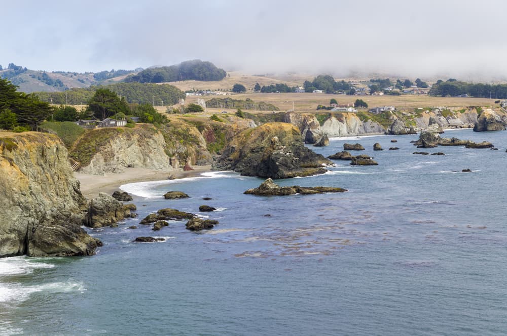 Rocky California coastline with fog and rocks in the water