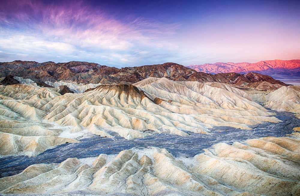 view of Zabriskie point badlands in Death Valley at sunrise colors