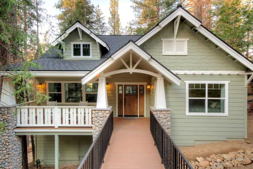 Gray craftsman cottage with stone detailing and patio