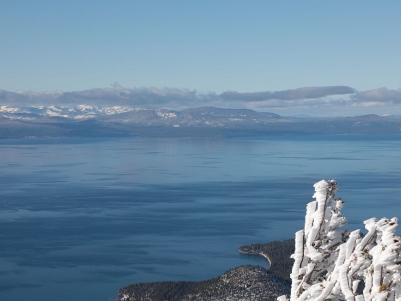 A winter in Lake Tahoe view from Heavenly Mountain accessed via a gondola ride: blue, blue lake, and white snow detail.