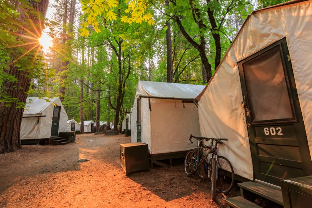 Canvas glamping tents in Yosemite forest with a bike outside one of teh tents.