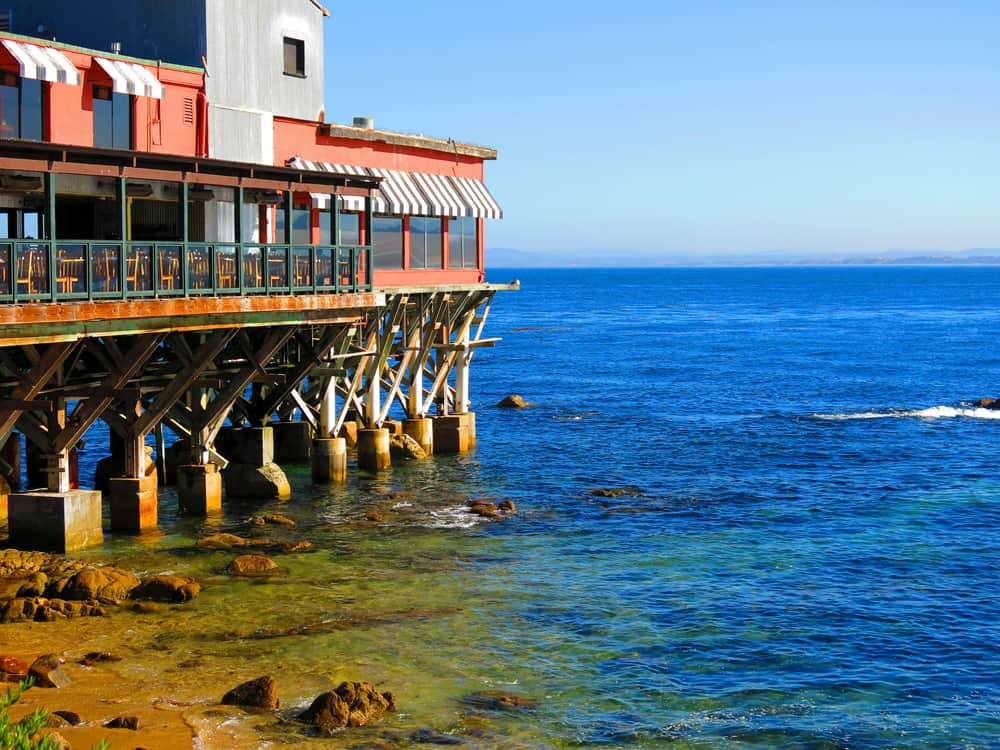 Restaurants on the water's edge in Monterey Bay: pier leading to blue sea