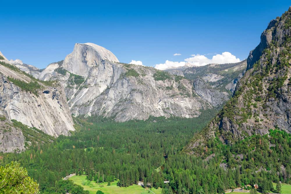 Views of green pine trees and granite landscapes, including Half Dome, from Columbia Rock viewpoint.