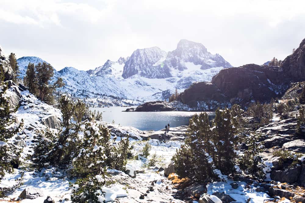 Banner Peak over Garnet Lake in the Ansel Adams wilderness after a fresh snow, everything covered in snow and white with cloudy sky.