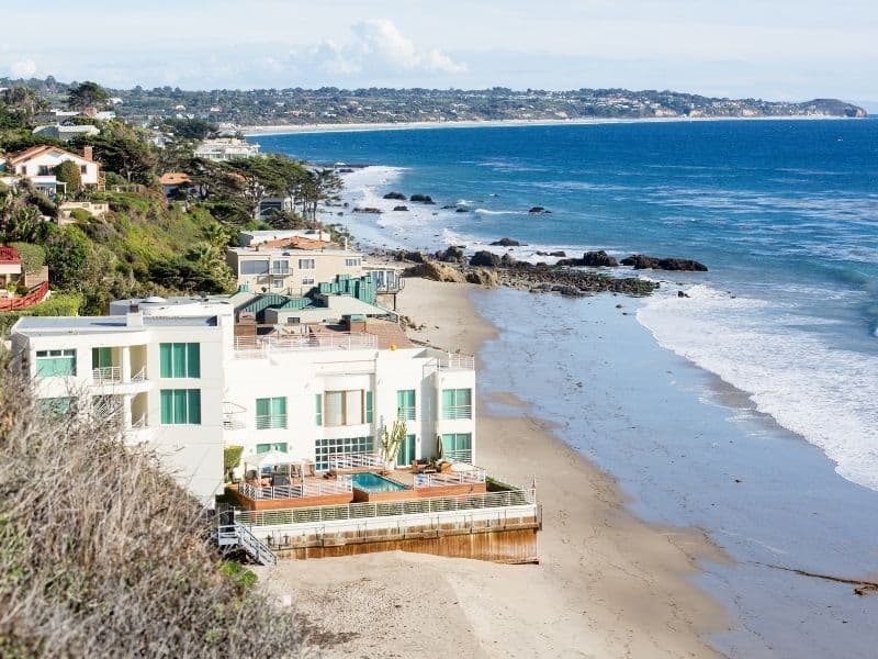 A view at a pricy Malibu home right on the beach with gorgeous ocean coastline everywhere around it.