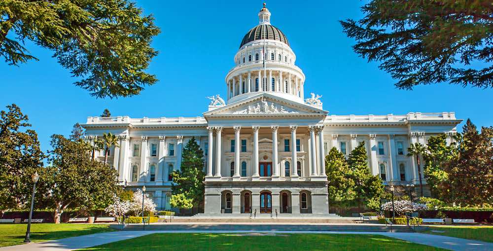 the sacramento state capitol building with dome and white pillars and trees