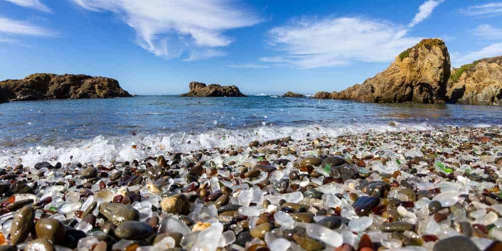 The pebbles of the Glass Beach at Fort Bragg, low angle with glass detail and water coming in as tide