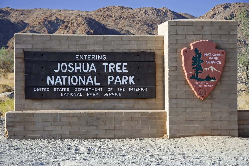 sign that reads 'entering Joshua tree national park' with the NPS insignia