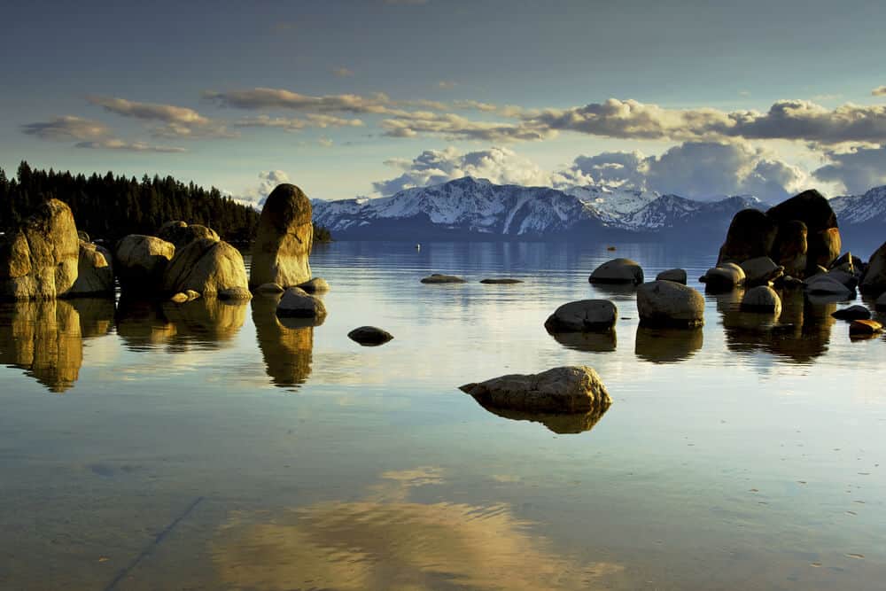 Rocks emerging from the still water around sunrise at Lake Tahoe seen from Zephyr Cove, Nevada side of Tahoe, a popular Tahoe camping spot.