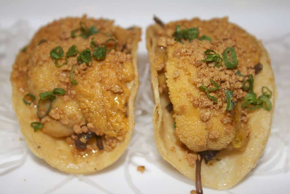 Small mini "tacos" with orange sea urchin roe topped with green onions, served at Nobu in Newport Beach.