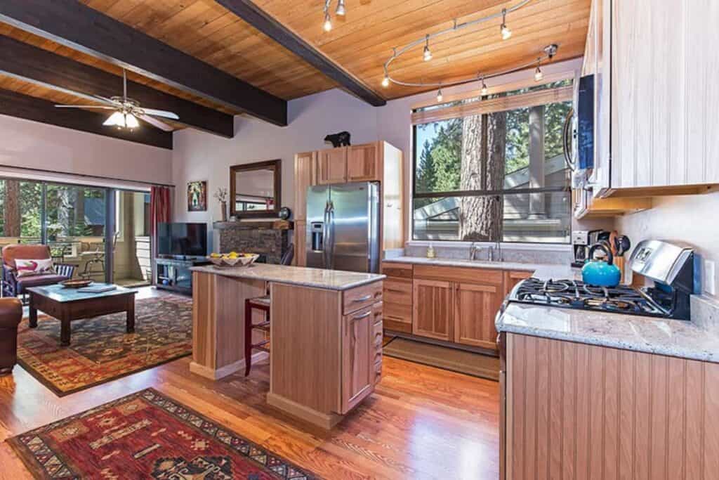 A modern condo in Tahoe with a gas range stove, kitchen island, living room with flatscreen TV and open floor plan.