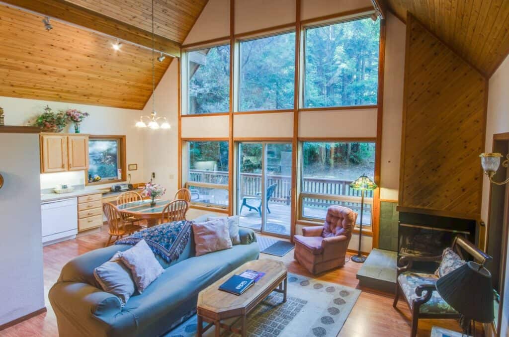 A cabin in Mendocino on Airbnb with floor to ceiling walls and wooden detailing with comfortable vintage furniture.