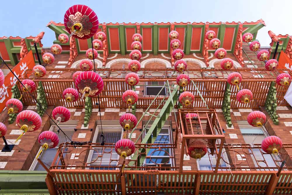 Red building with green details and strings of red Chinese lanterns coming down from the roof