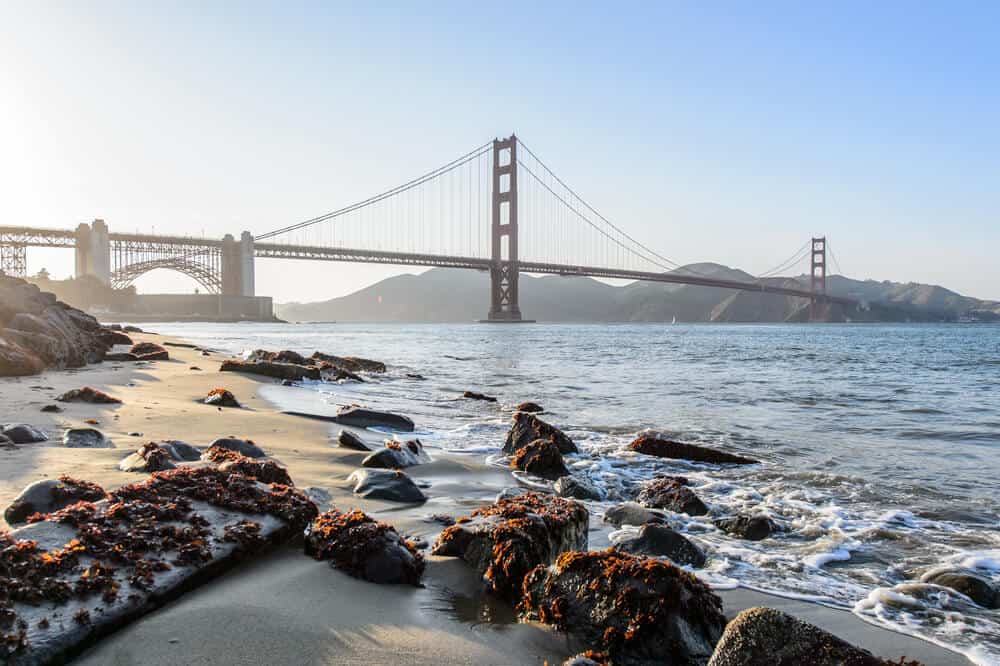 Rocks strewn on the beach overlooking the Golden Gate Bridge at sunrise or sunset with soft light