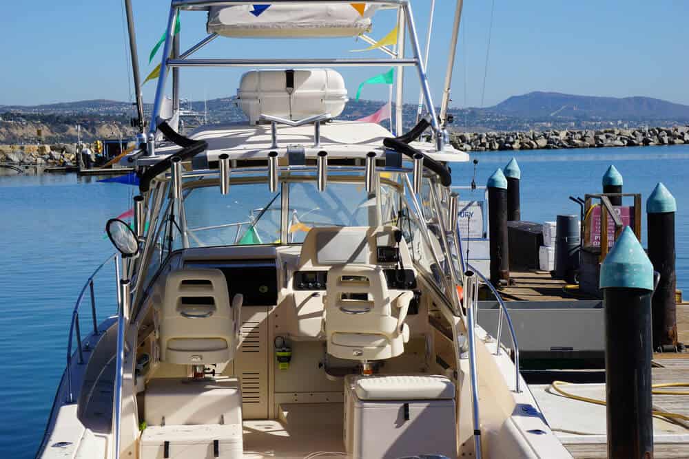 A fancy white sportfishing boat with colorful flags docked at a harbor in Dana Point.