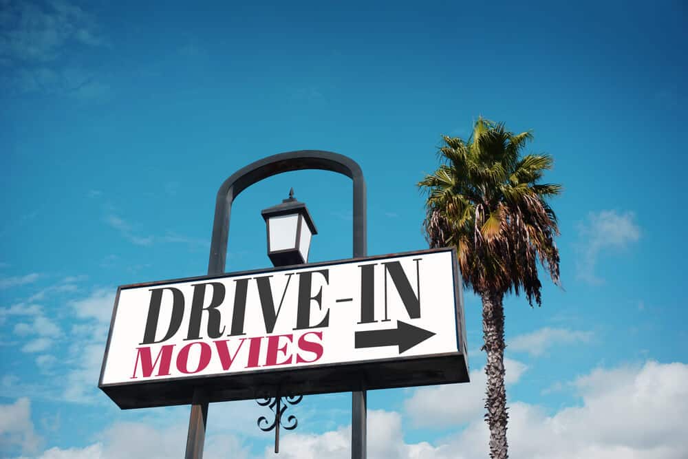 sign for drive in movies with palm trees in background