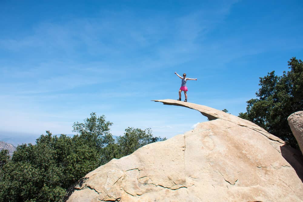 person standing on a rock that looks like a thin potato chip