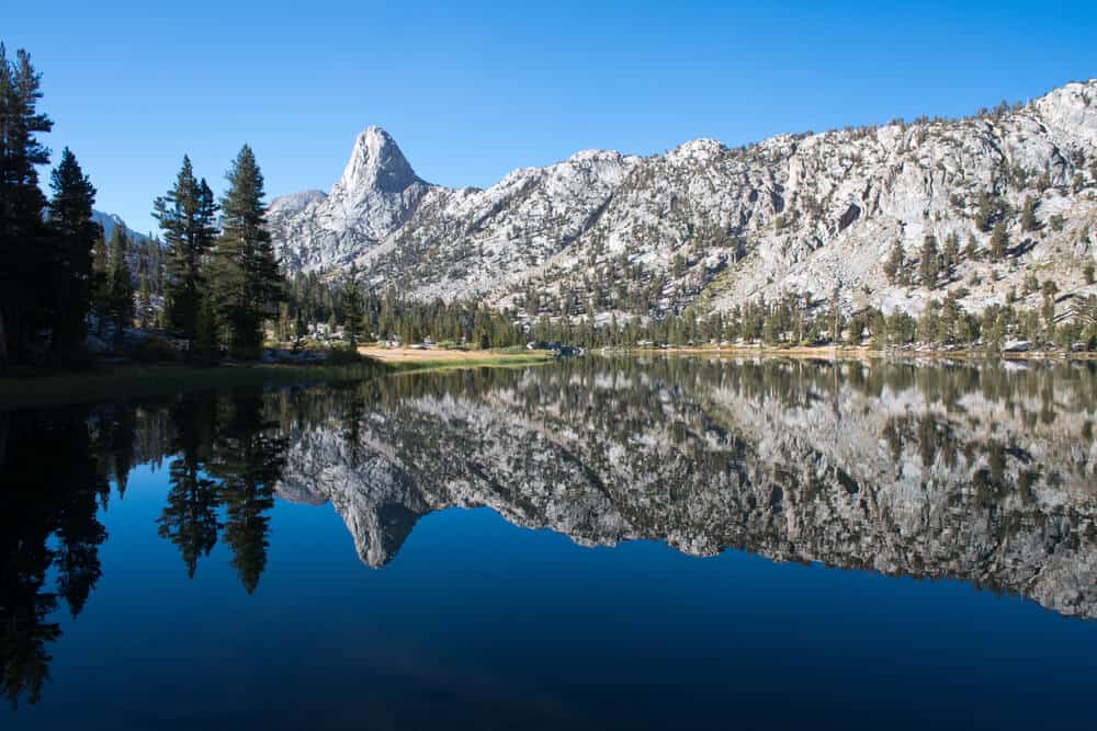 Fin Dome mirror reflection in Rae Lake in Kings Canyon National Park, blue water  reflecting back granite mountain on a clear day's hike
