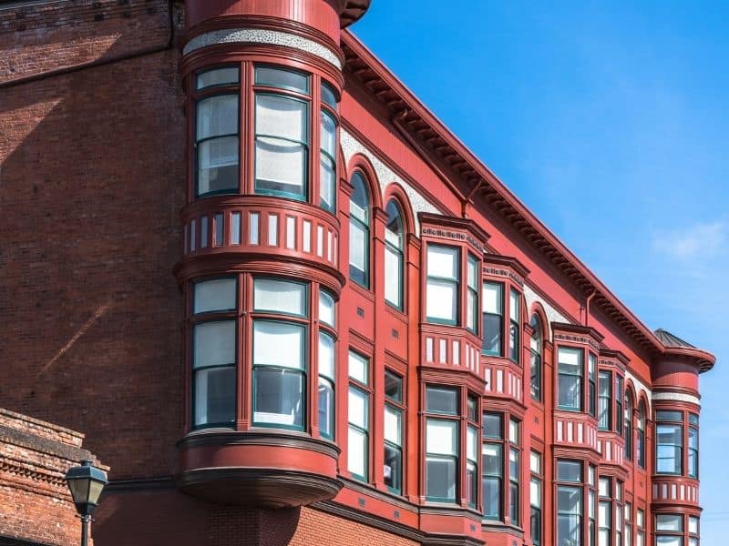 Architectural details of a red building in Eureka's Old Town area, with rounded windows and other Victorian touches