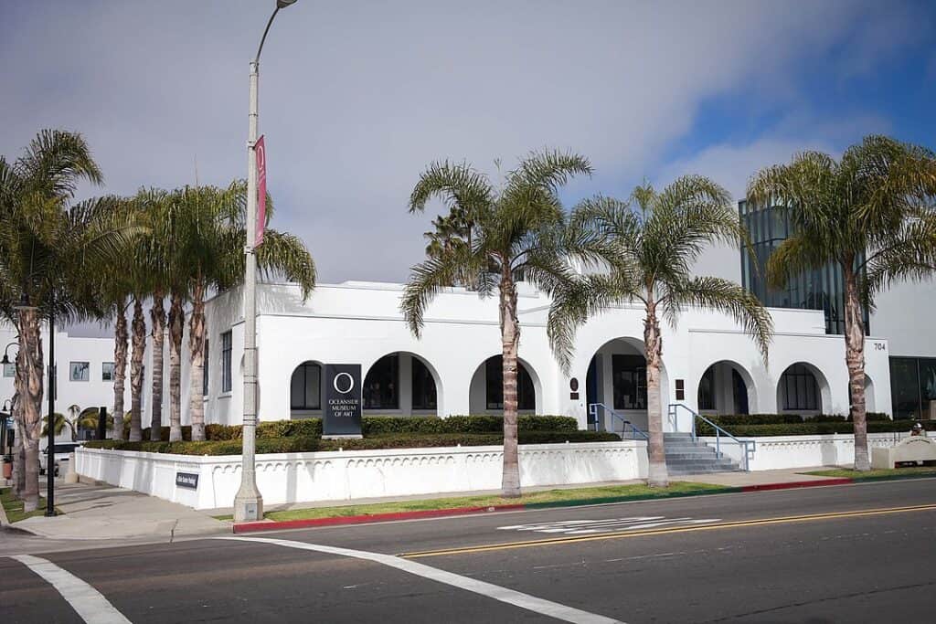 White building with archways surrounded by palm trees