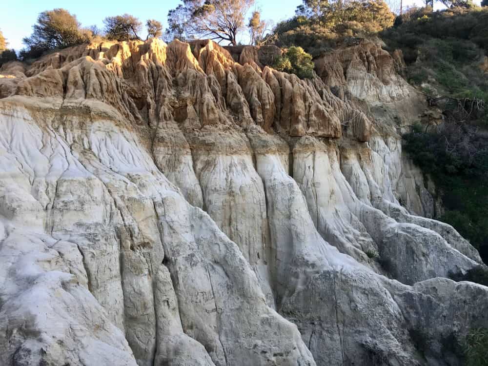 white and orange sedimentary rock in a canyon covered by shadow