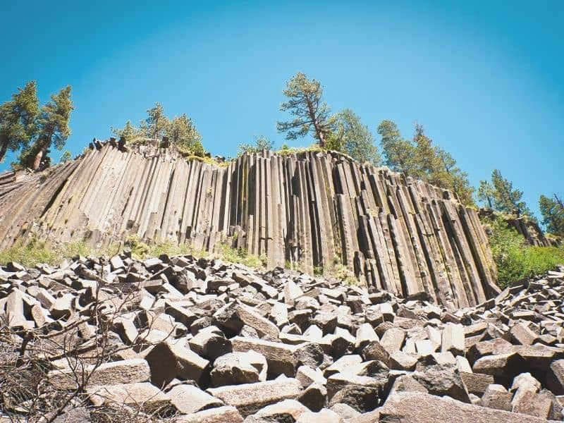 the black basalt columns of devil postpile being shown on a sunny day in california