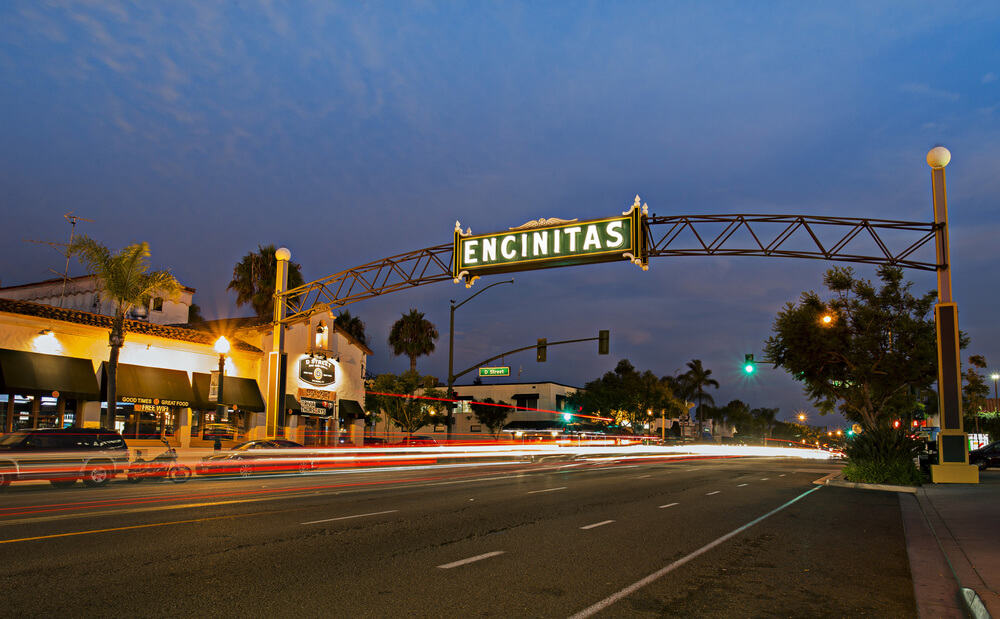 nighttime view of the encinitas sign with light trails from passing cars