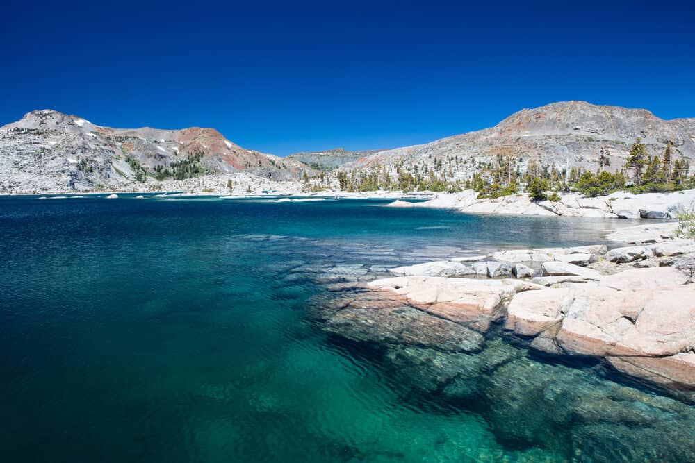 Perfectly clear water in an alpine lake in the Sierras surrounded by grey mountain rock