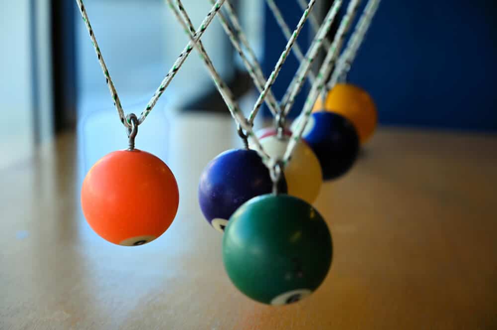 Billiard balls suspended on string to form a pendulum, shown at the science museum in Lodi