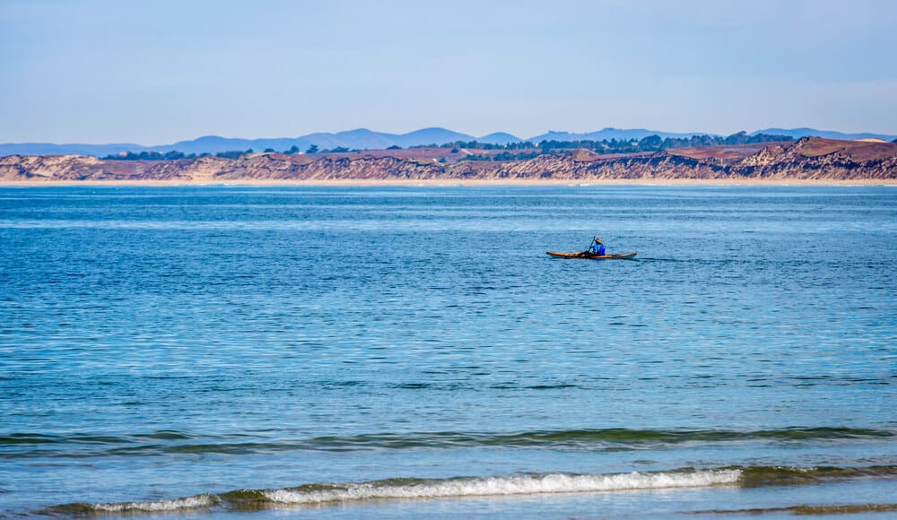 Lone kayaker paddling out to the bay near Monterey, California