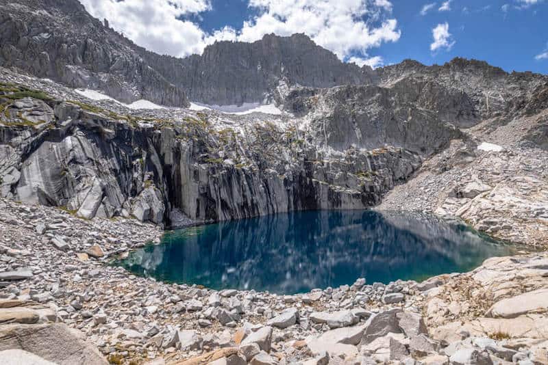 a mirror-lake still alpine lake surrounded by basalt columns and rocks