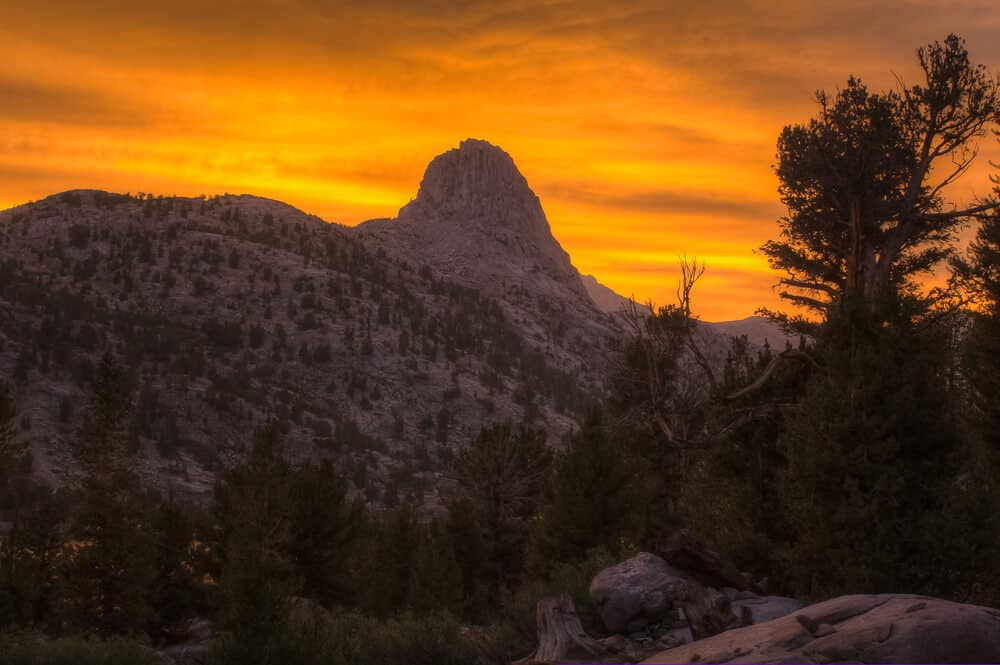 A colorful sunset lights the sky above the mountains of the Rae Lakes and the Fin Dome in California's high sierra
