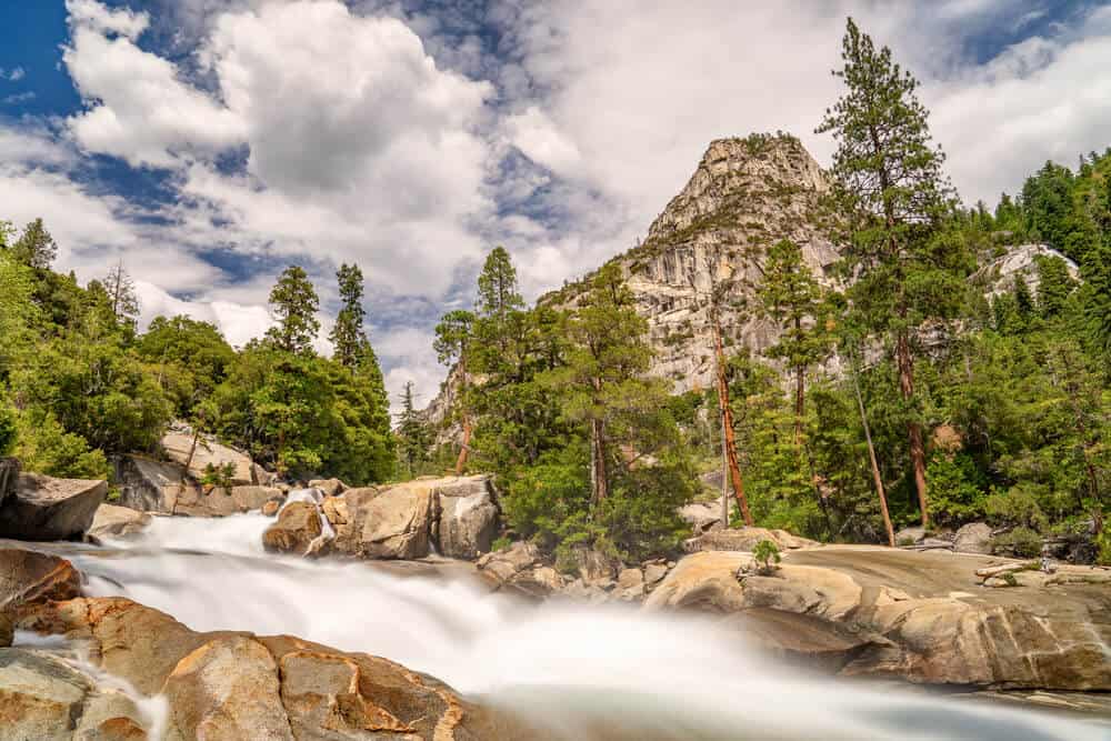 Busy river flowing in a summery landscape in Kings Canyon along Rae Lakes Loop in long exposure, creating a beautiful blurred river.