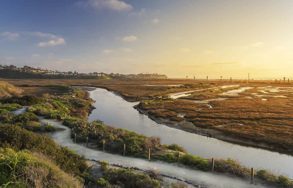 sunset over the san elijo lagoon - wetlands interspersed with water along a coastal path for hiking in encinitas