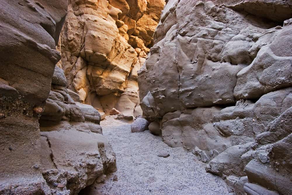 A rocky orange slot canyon which has narrow walls you can hike through in Anza Borrego Desert.