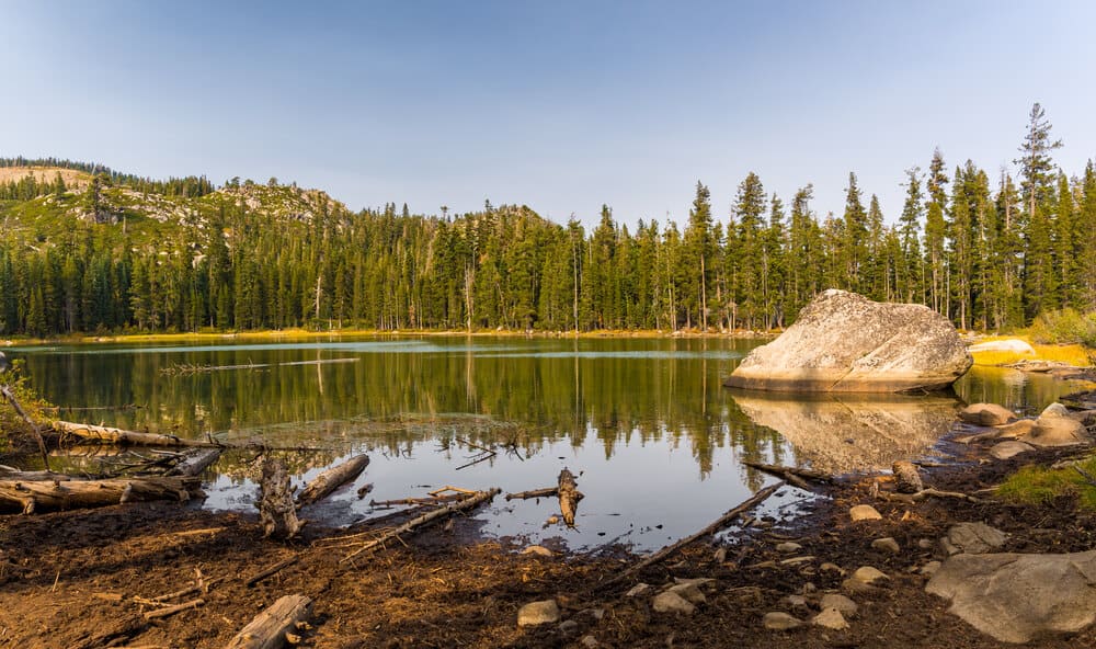 A scenic view of a calm Summit Lake with forest reflections along the Pacific Coast Trail, in the tahoe to yosemite trail hike section.
