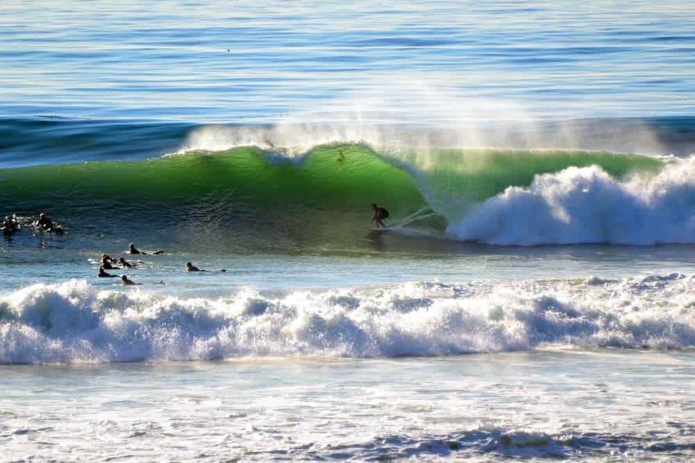 many surfers gathering on the waves of swamis surf breaks, a popular thing to do in encinitas