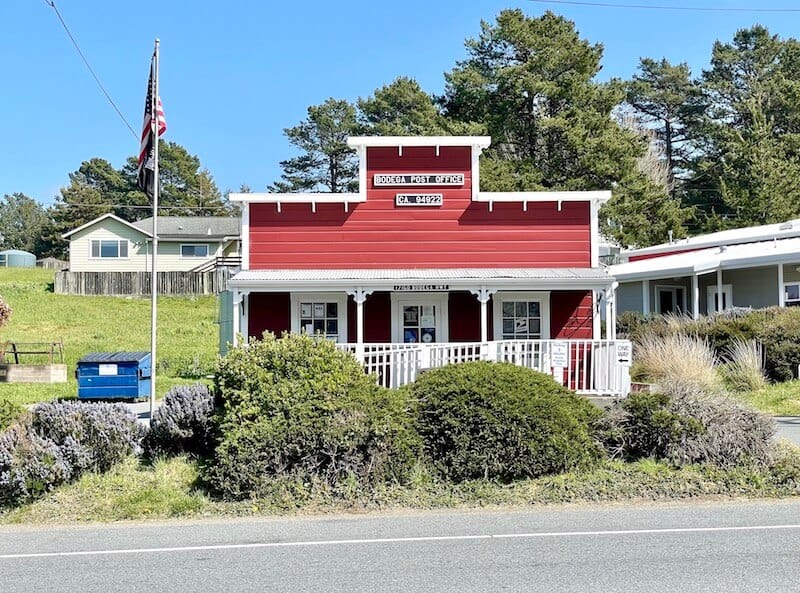 tiny red post office with american flag pole