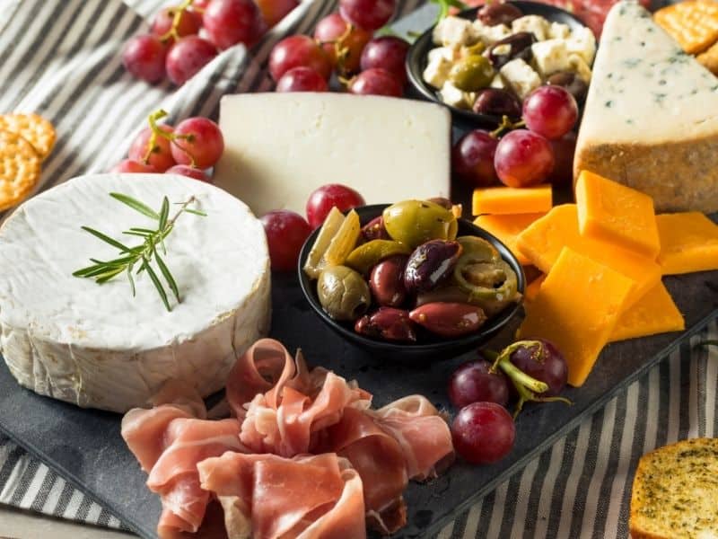 charcuterie board with cheese and meats on a tablecloth