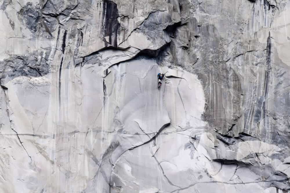 person climbing the granite face of el capitan rock in yosemite