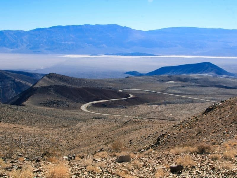 view of the death valley basin below with a curved road and salt flats in the distance