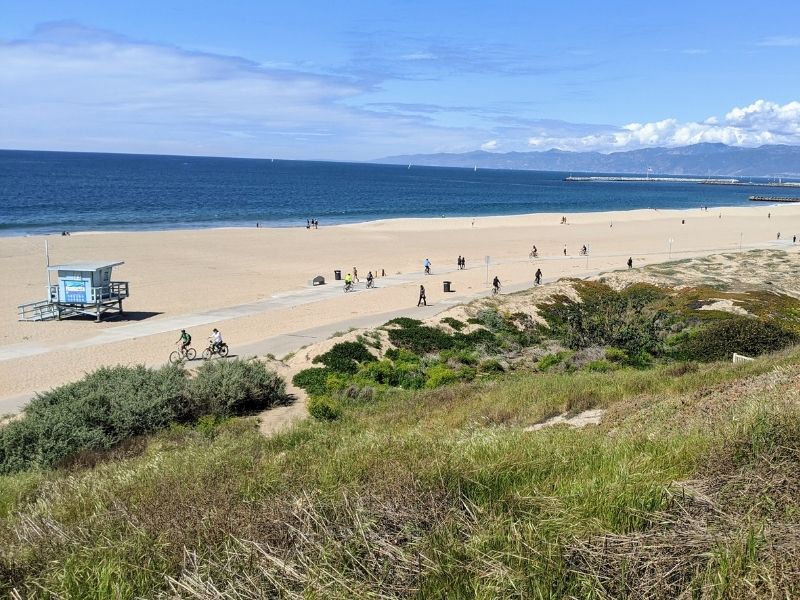 people on the beach walking and using bicycles on playa del ray, an off beat los Angeles date idea