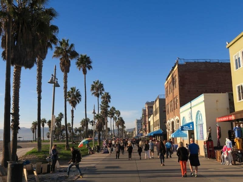 venice beach boardwalk with lots of people walking and watching