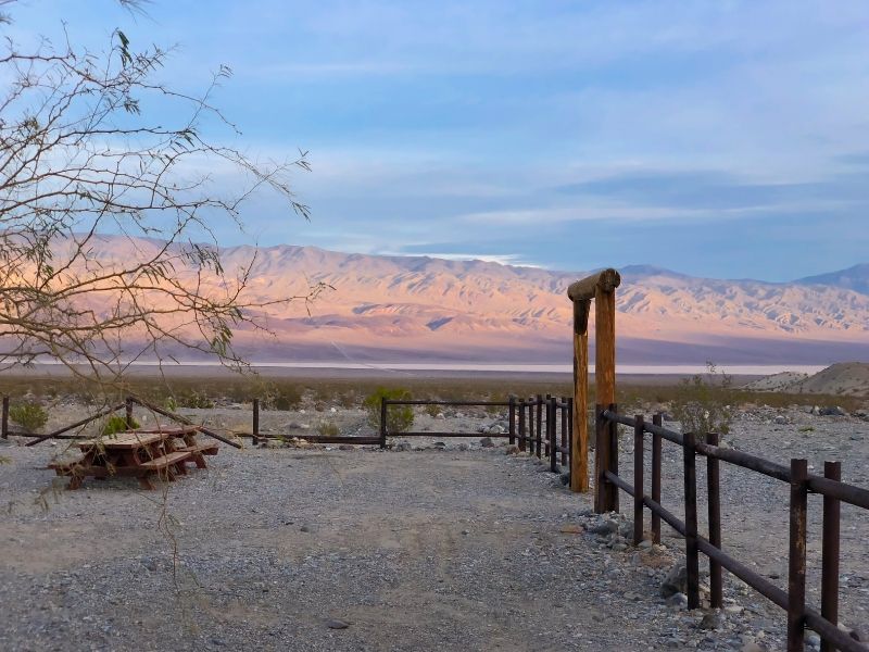 panamint springs campground with an empty picnic table and light on the mountains