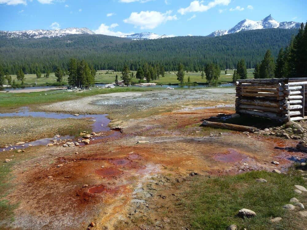 springs in yosemite, reddish-looking deposits around spring water, mountains in the distance