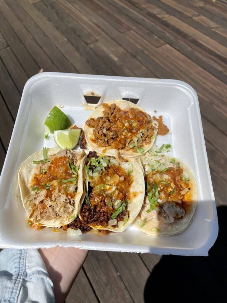 a styrofoam tray with four tacos