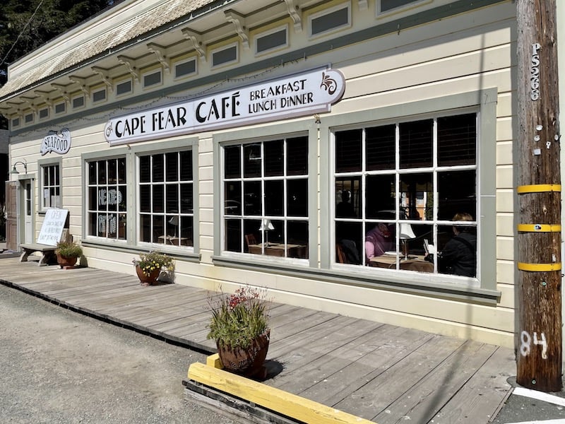 a pale-yellow painted restaurant with the sign that says 'cape fear cafe breakfast lunch dinner'