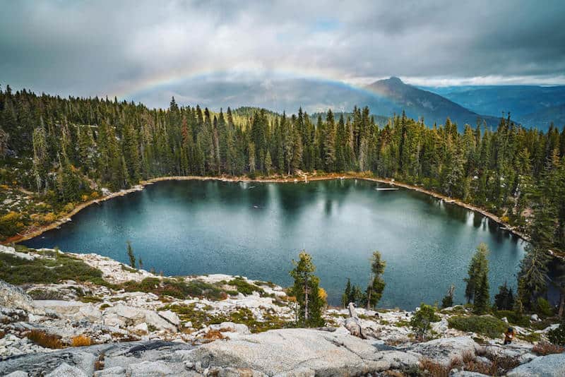 photo of a little lake on a mountain plateau with a rainbow faintly in the background