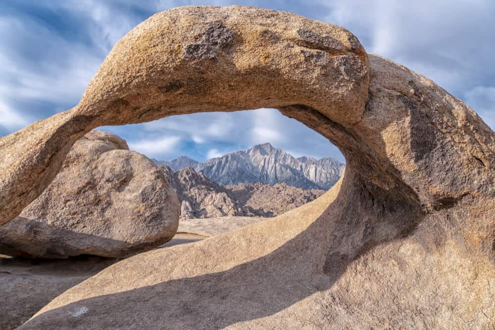 The arch of Mobius Arch showing a keyhole through which the mountains of the Sierra Nevada Range can be seen.